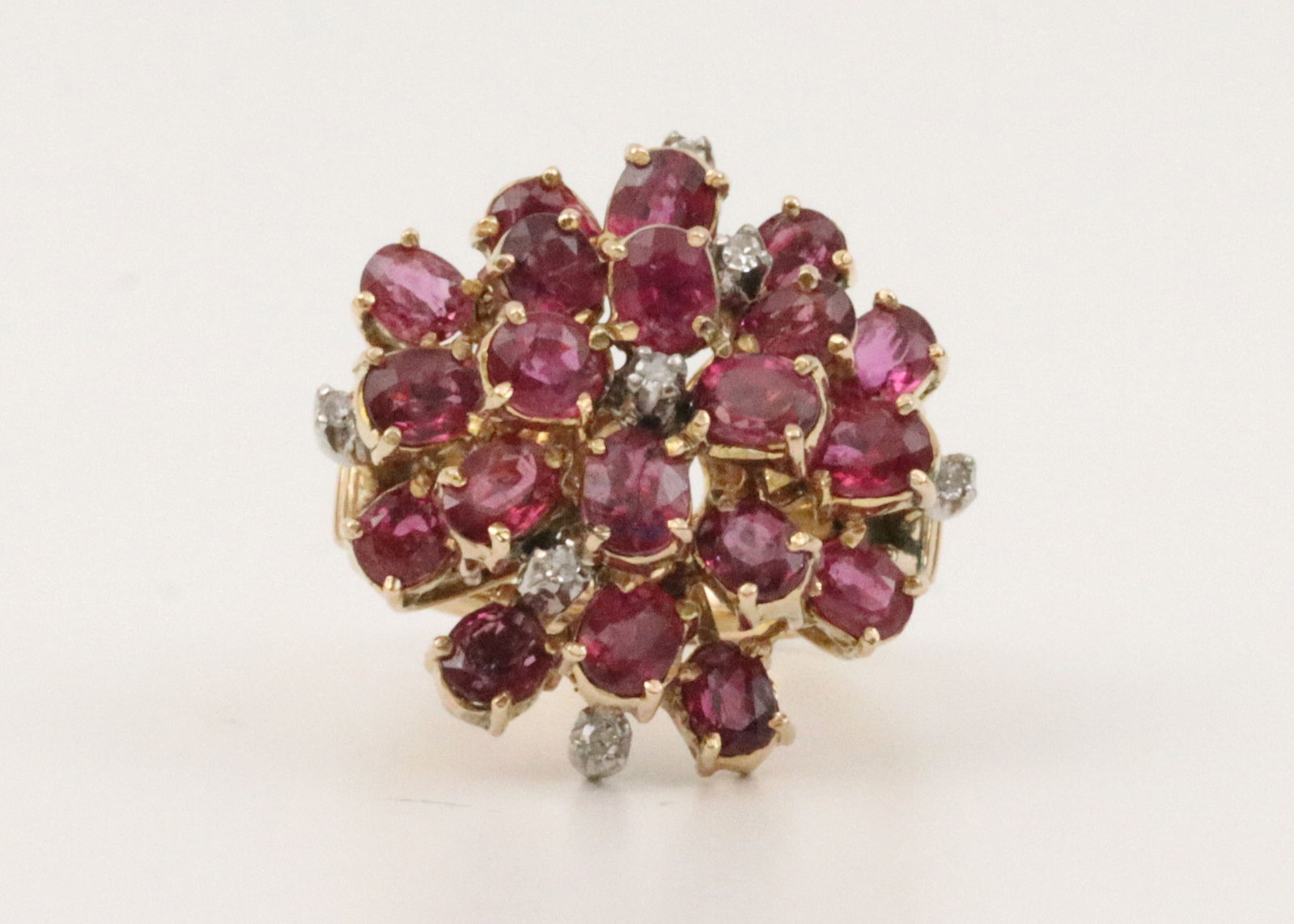 14K DIAMOND & RUBY CLUSTER RING: set with 30 oval rubies approx. 3.00ctw, accented with 7 round natural melee diamonds, overall ring head 23mm, in yellow gold, stamped 14K, size 7.25, 10.3gms., Opening Bid $400Note: Leighton makes no
