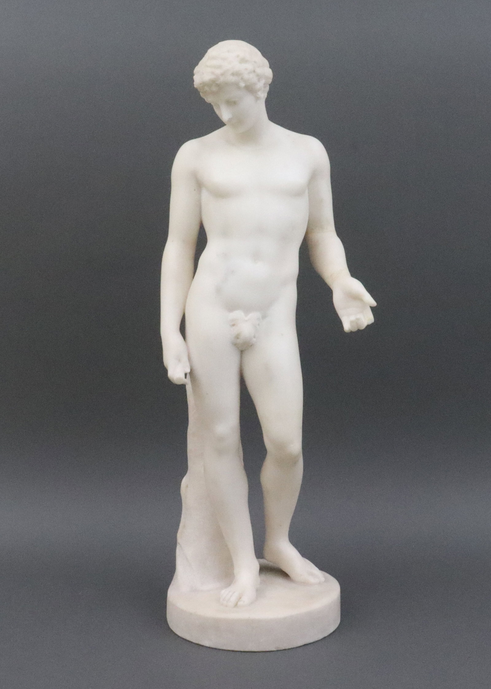 ALABASTER FIGURE OF THE CAPITOLINE ANTINOUS: carved alabaster figure of Antinous (after the antique in the Musei Capitoline, some now consider to be Hermes), depicted standing afront a tree trunk, unsigned, estate piece, condition issues