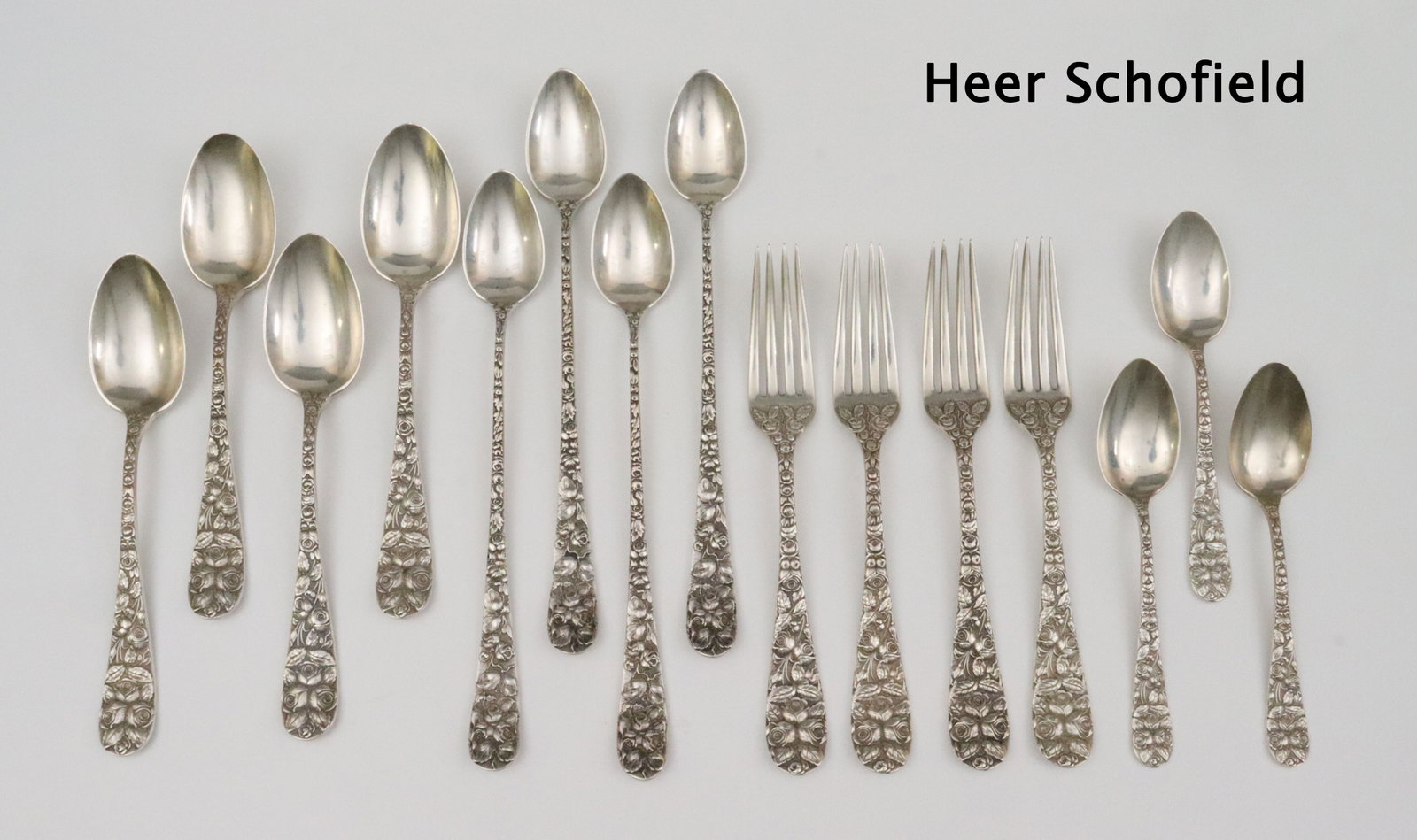 (36) STERLING FLATWARES IN REPOUSSE ROSE PATTERNS: by various makers, Heer Schofield stamped 'Baltimore Rose' pieces include 4 place forks (7.2in.), 4 tablespoons (7in.), 4 iced tea spoons (8.4in.), and 3 teaspoons, S. Kirk & Son pieces include 4 sala