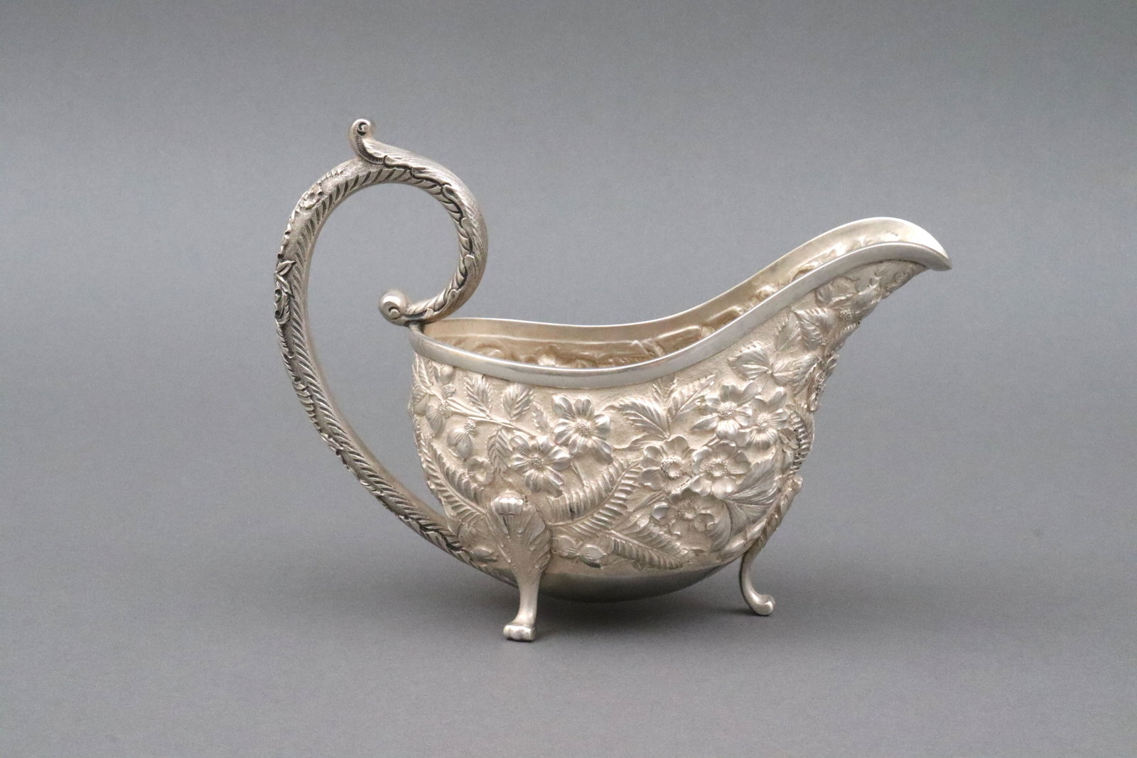 HARRIS & SHAFER STERLING REPOUSSE SAUCE BOAT: hand hammered, in allover floral, fern and leaf design against a stippled body, raised on paw feet, stamped 'Harris & Shafer Co. Sterling 925/1000', no monogram, very shallow body dents under bowl