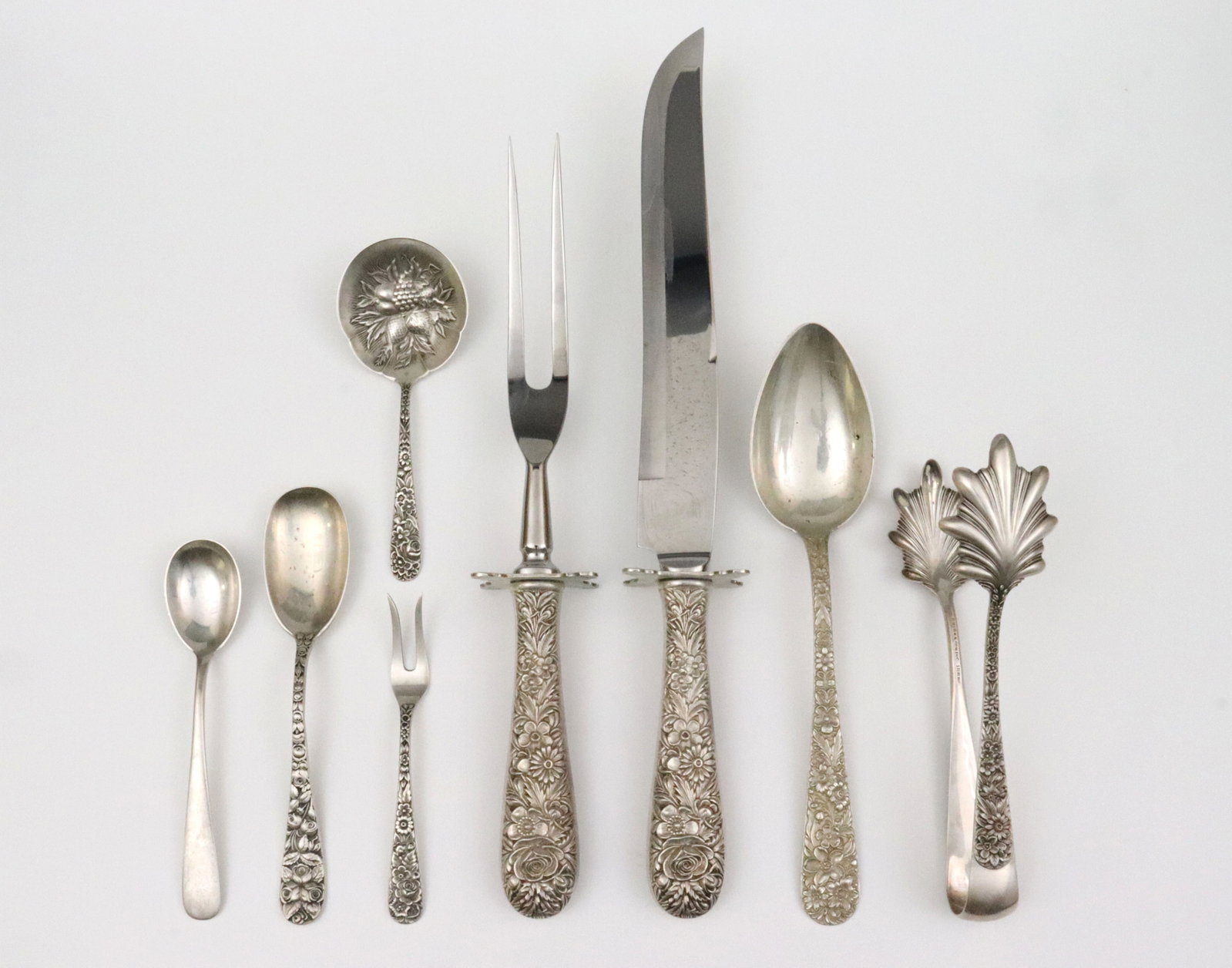 (8) PIECE S. KIRK & SON STERLING FLATWARE GROUP: in various patterns, primarily in repousse Rose (see images), includes a 2-piece carving set, a bon bon spoon, a lemon fork, a large pair of ice tongs, a serving spoon, and 2 sizes of dessert spoons,