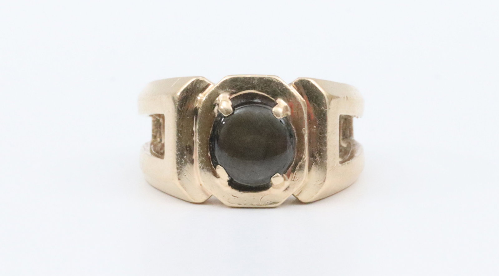 14K HEMATITE RING: in wide split shank design, set with a round 7mm hematite cabochon, in yellow gold, tests 14K, size 6.5 (sizing line), 6.1gms., Opening Bid $200
