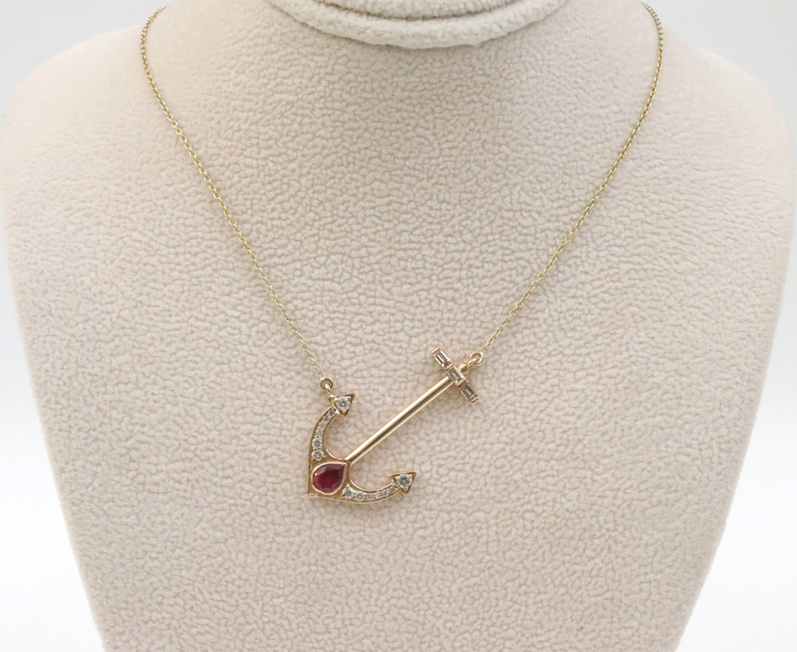 14K DIAMOND & RUBY ANCHOR PENDANT NECKLACE: the pendant set with a pear-cut ruby approx. 0.50ct, and 27 round and baguette natural diamonds approx. 0.53ctw, stamped 585, pendant length 1.2in., on 17in. adjustable cable chain, 3.9gms., Opening