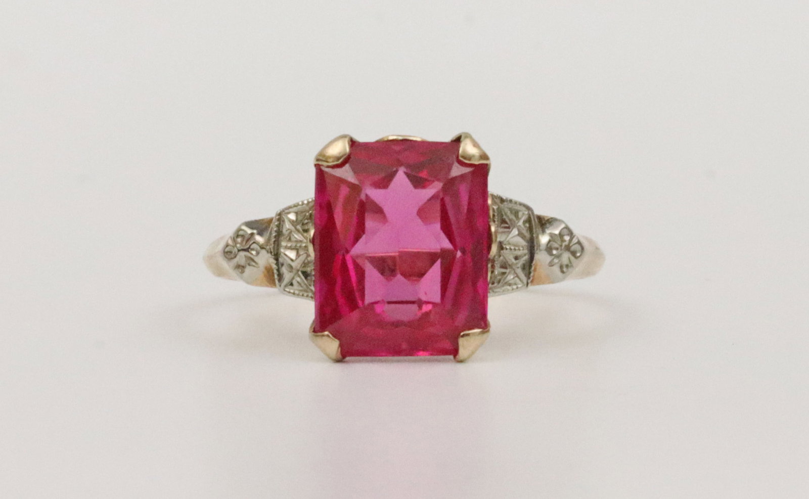 10K RUBY RING: set with a 10x8mm ruby stone, in yellow gold, shoulders in white detailed gold, stamped 'Dason 10K', size 7.25, 2.3gms., Opening Bid $150Note: Leighton makes no claims or guarantees as to a ruby being