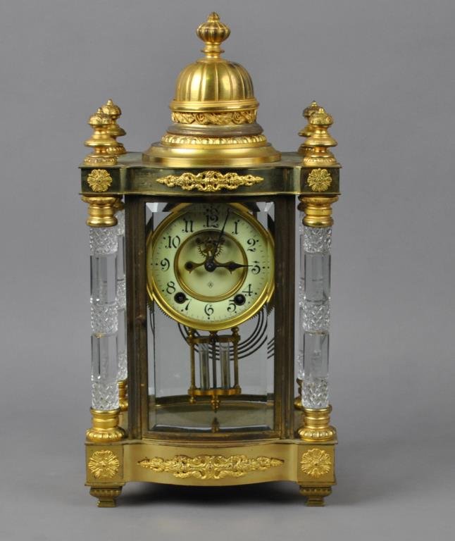 ANSONIA ‘UTOPIA’ CRYSTAL REGULATOR CLOCK: gilt-brass and beveled glass case with bow front, two doors, four glass free-standing columns, Arabic numeral enameled dial with open escapement, eight-day time and strike movement, faux-mercury pendu