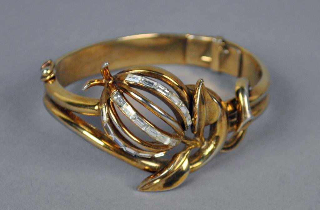 TRIFARI RETRO BANGLE: in floral form set with white paste baguettes (2 stones with minor glue residue), hinged and with safety clasp, signed, flower width 1.5in., interior diameter approx. 2x2.25in.