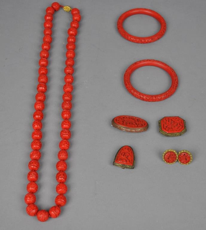 7-PIECE CINNABAR OR CINNABAR-STYLE JEWELRY GROUP: including a 32" beaded necklace, two bangles, a pin, two shoe buckles, and a pair of screw-back earrings