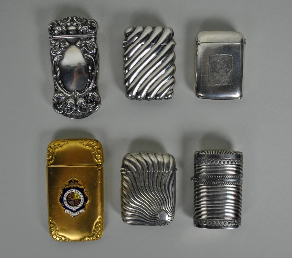 (6) VINTAGE MATCH SAFES: 3 marked sterling, another bearing the enameled emblem of the Most Noble Order of the Garter that reads ‘honi soit qui mal y pense’, tallest 3in.