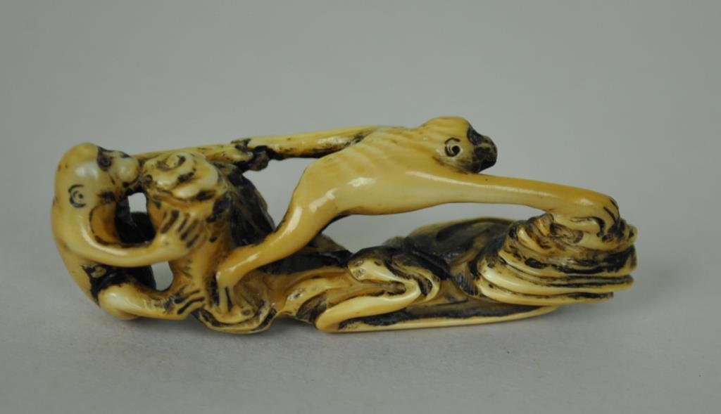 JAPANESE CARVED IVORY NETSUKE OF MONKEYS: depicted playing or crossing a brook, holding hands, signed, 2.25in., Estate Collection