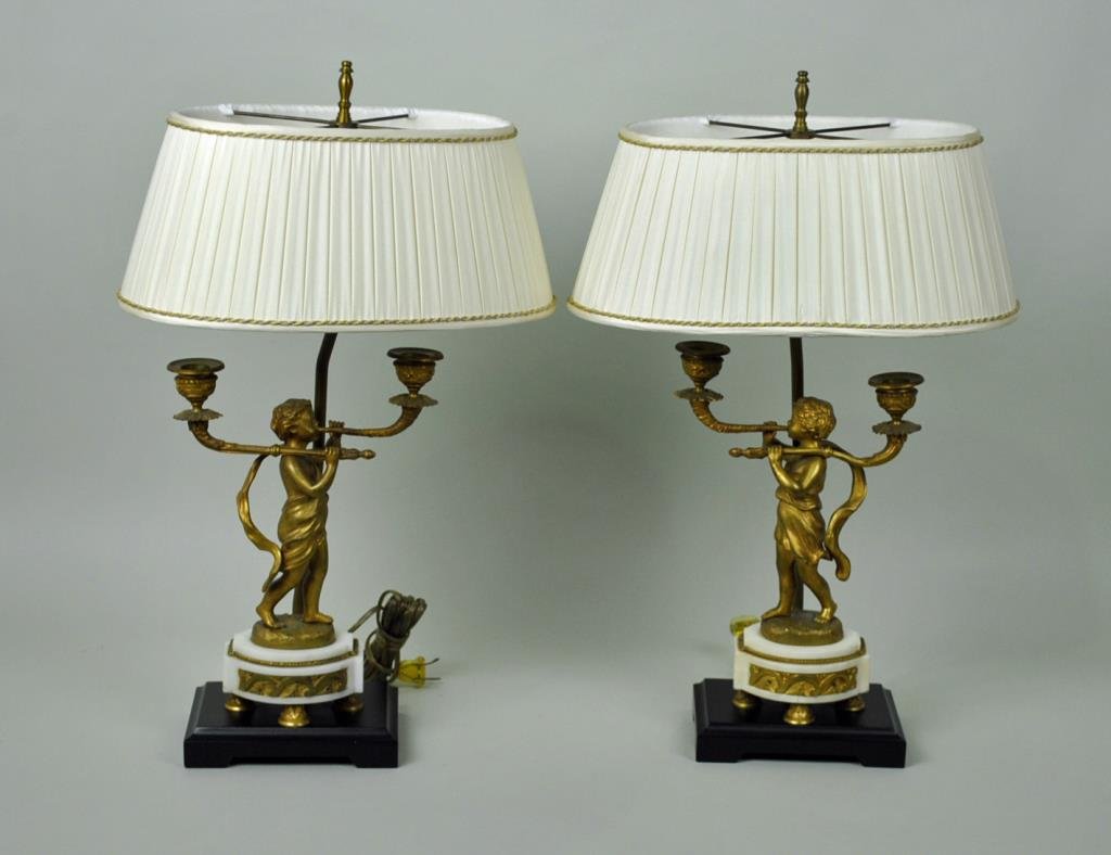 PAIR GILT BRONZE 2-ARM PUTTI CANDELABRA: fitted as lamps, each cast as a putto blowing a horn, 19thC., later fittings, no drill holes, bronze mounted alabaster base (chip to corner of one base), removable bobeches, 11.5in., overall 21in.