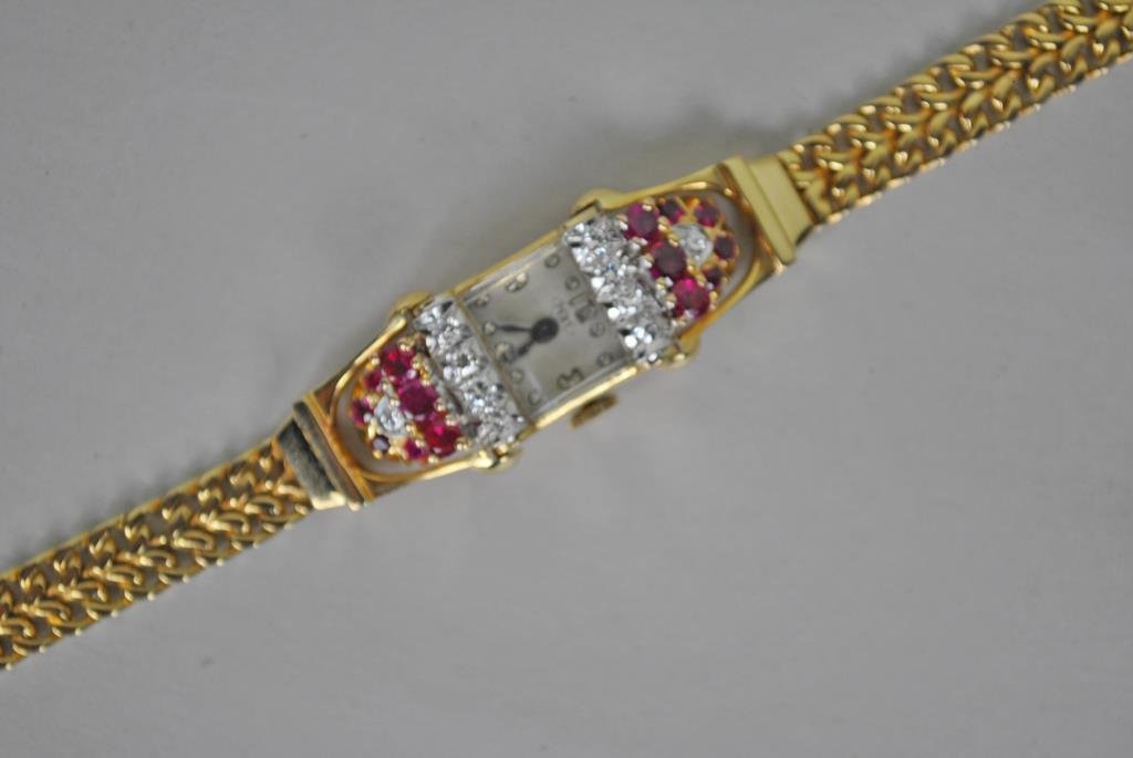 RETRO RUBY & DIAMOND WATCH BY PERY, 1.70CTW: set with 24 round rubies and diamonds approx. 1.70 carats, set in yellow gold, case interior stamped 14K Solid Gold, bracelet stamped 14K, Swiss movement stamped Coronet Watch Co., 17 jewels, overall 