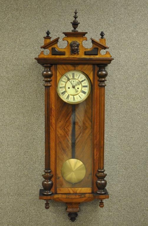 WALNUT DOUBLE WEIGHT VIENNA REGULATOR WALL CLOCK: 19thC., unknown maker, the pediment with applied female mask, case with turned half columns, brass pendulum, 50x18in.