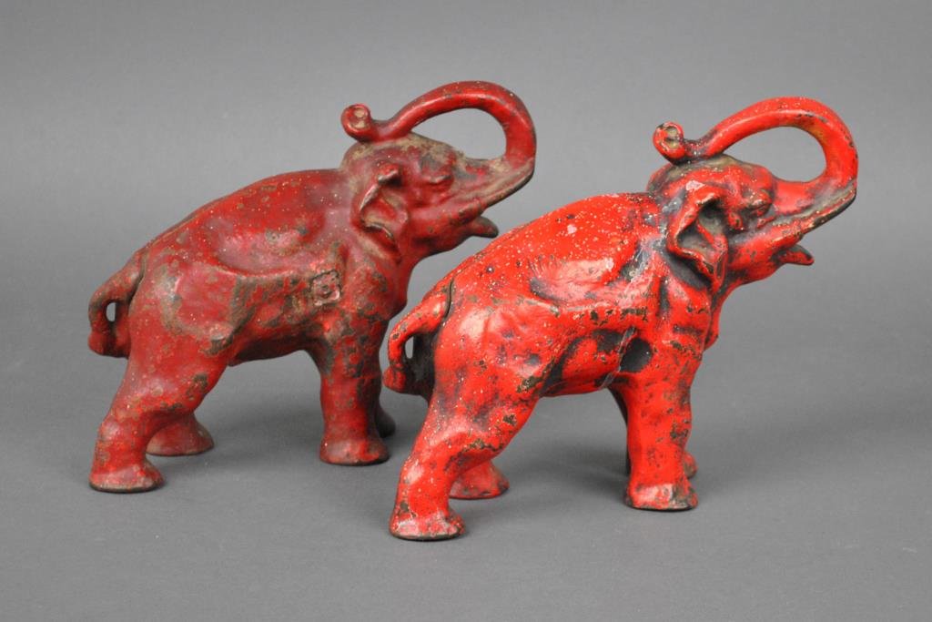 (2) ANTIQUE CAST IRON ELEPHANT DOORSTOPS: red painted and nearly identical, one slightly taller and heavier, unmarked, paint chips and losses, minor paint splatter, 8-8.5in.