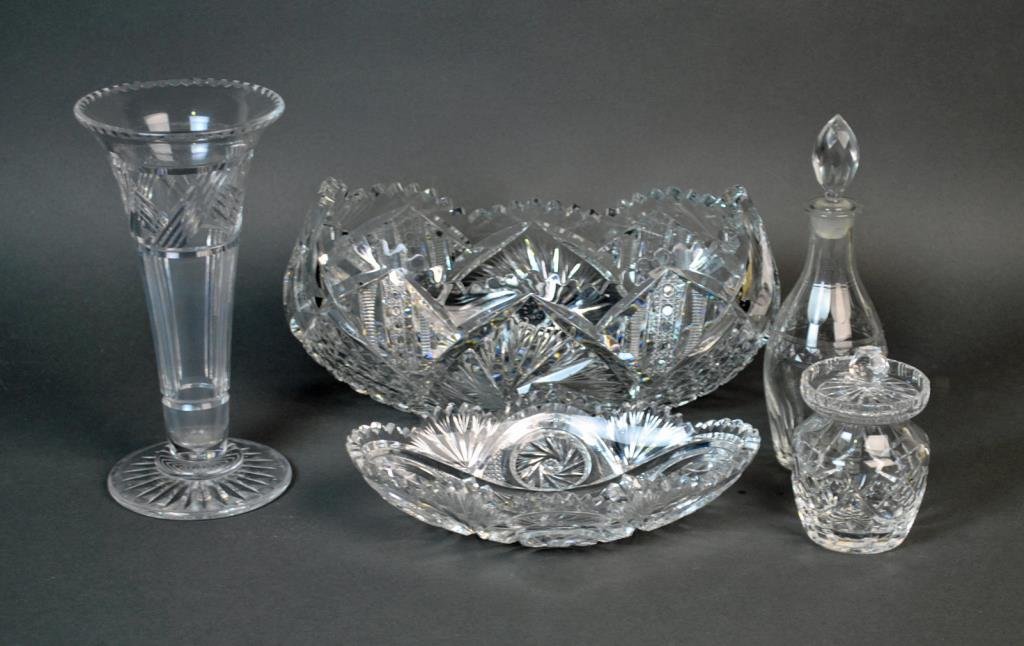 (5) CUT GLASS TABLEWARES: including a brilliant cut banana bowl and relish dish, a Waterford lidded condiment, an English footed trumpet vase, and a liquor decanter (possibly St. Louis, small chip to stopper tip), tallest 10in