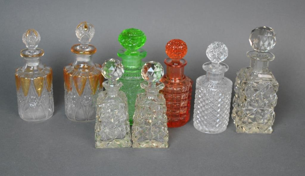 (8) PRESSED GLASS PERFUME BOTTLES: including a set of 3 with crystal stoppers, a set of 2 with copper luster panels, both sets in two sizes, some Val St. Lambert, etc.