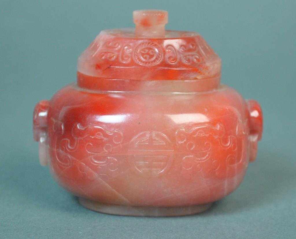 CHINESE CARVED CARNELIAN AGATE COVERED JAR: with symbol of longevity, raised foot, conforming lid with finial, minor chip under lid, 3x3.5in.