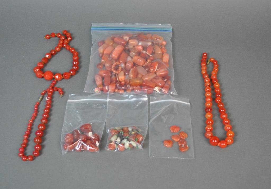 (250+) LOOSE CARNELIAN BEADS: including 10 carved Buddha head beads, 6 carved monkey beads, Shou carved beads with barrel-shaped jade beads and green jade disc spacers, etc.