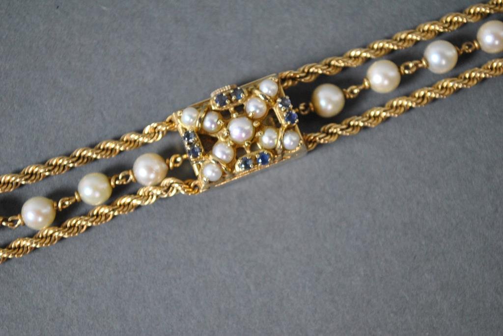 GENEVA GOLD, PEARL & SAPPHIRE BRACELET WATCH: dial marked Geneva, movement marked 'Kalish Watch Co. Swiss 17 Jewels', case 19x14mm, rope chain bracelet set with 6mm pearls, case and clasp stamped 14K, safety catch, 7in., 25.6gms. excluding moveme