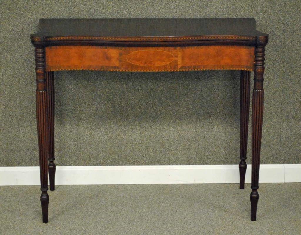 SHERATON INLAID MAHOGANY DEMILUNE GAMES TABLE: marquetry inlaid edges, burlwood skirt panels with banding, marquetry trim and oval center medallion, wood hinge, reeded legs, minor marquetry losses, 29.5x35x18in.