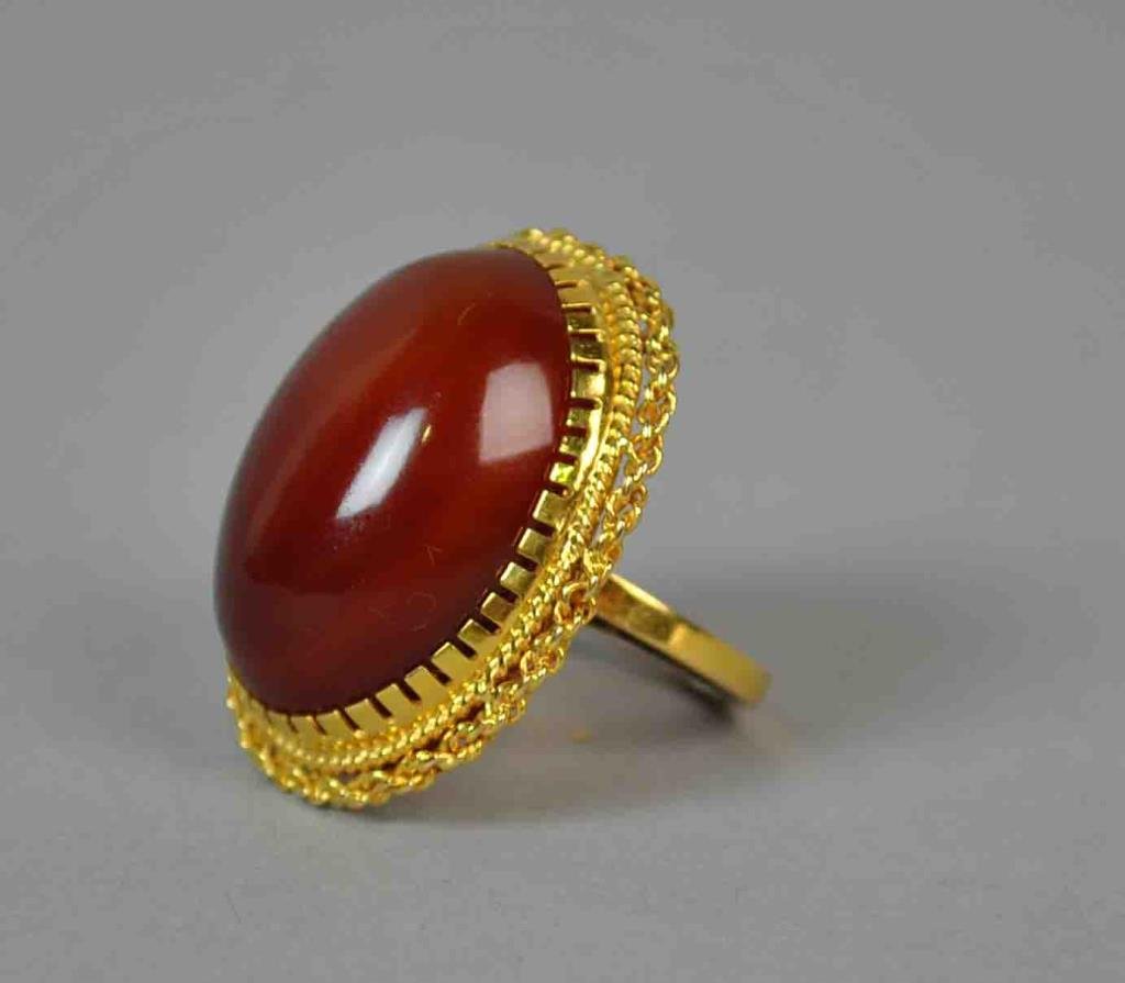 LARGE CARNELIAN DINNER RING: set with a large oval stone approx. 24x17mm, yellow gold setting tests 14K, size 5.25, 10.9gms.