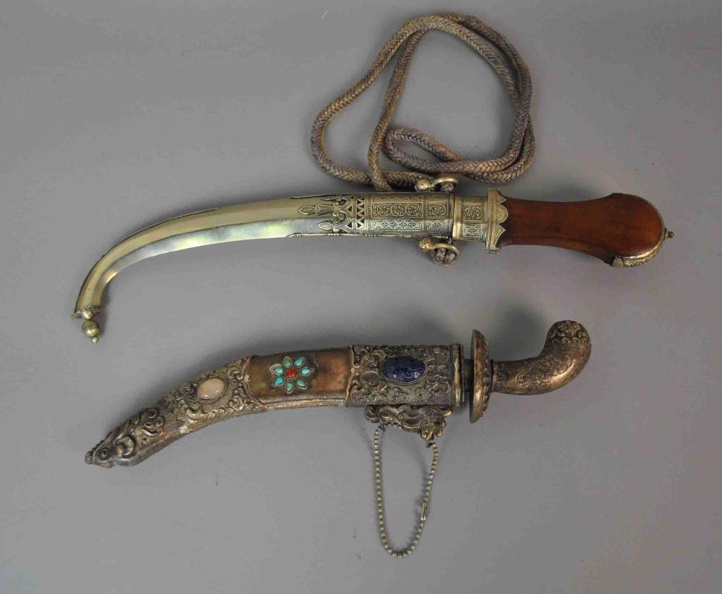 (2) CONTEMPORARY MIDDLE EASTERN STYLE DAGGERS: both with curved blades, one with jeweled scabbard, the other with wood handle and brass trim, longest 17in.