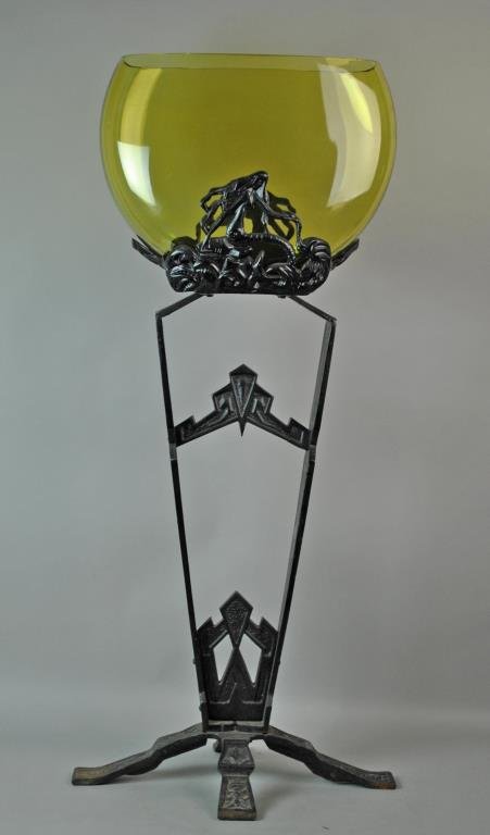 DECO CAST IRON & GLASS FISH BOWL ON STAND: amber colored glass tank (appears original to the stand), supported with relief mermaids, the uprights decorated with classic deco symbols, intaglio insects and storks, overall 40x16x9in.