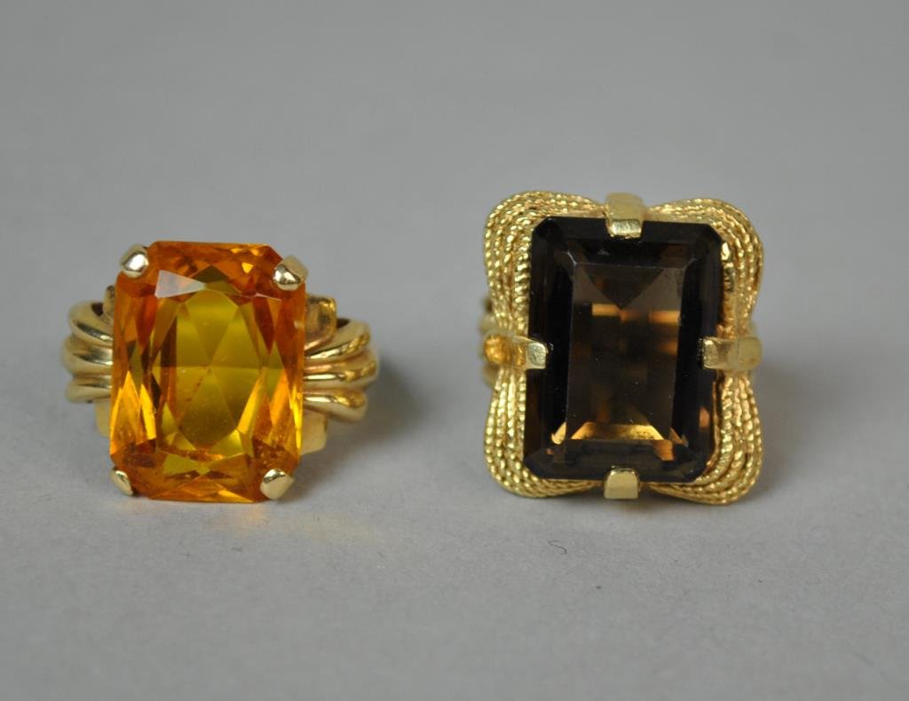 (2) GOLD & BERYL RINGS: one set with a brown stone approx. 18x13mm, in rope trim setting, size 6.5, the other set with a yellow stone approx. 18x13mm, in retro style setting, size 7.75, each in yellow gold stamped 14K, gross
