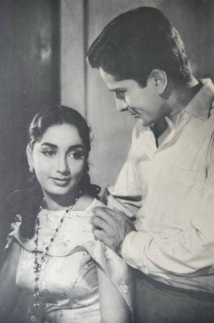 CLASSIC BOLLYWOOD ROMANCE IN BLACK AND WHITE - PRINT: CLASSIC BOLLYWOOD ROMANCE IN BLACK AND WHITE - PRINTTHIS TIMELESS BLACK AND WHITE PHOTOGRAPH CAPTURES AN INTIMATE AND GRACEFUL MOMENT BETWEEN A YOUNG MAN AND WOMAN, EVOKING THE ESSENCE OF VINTAGE HIND