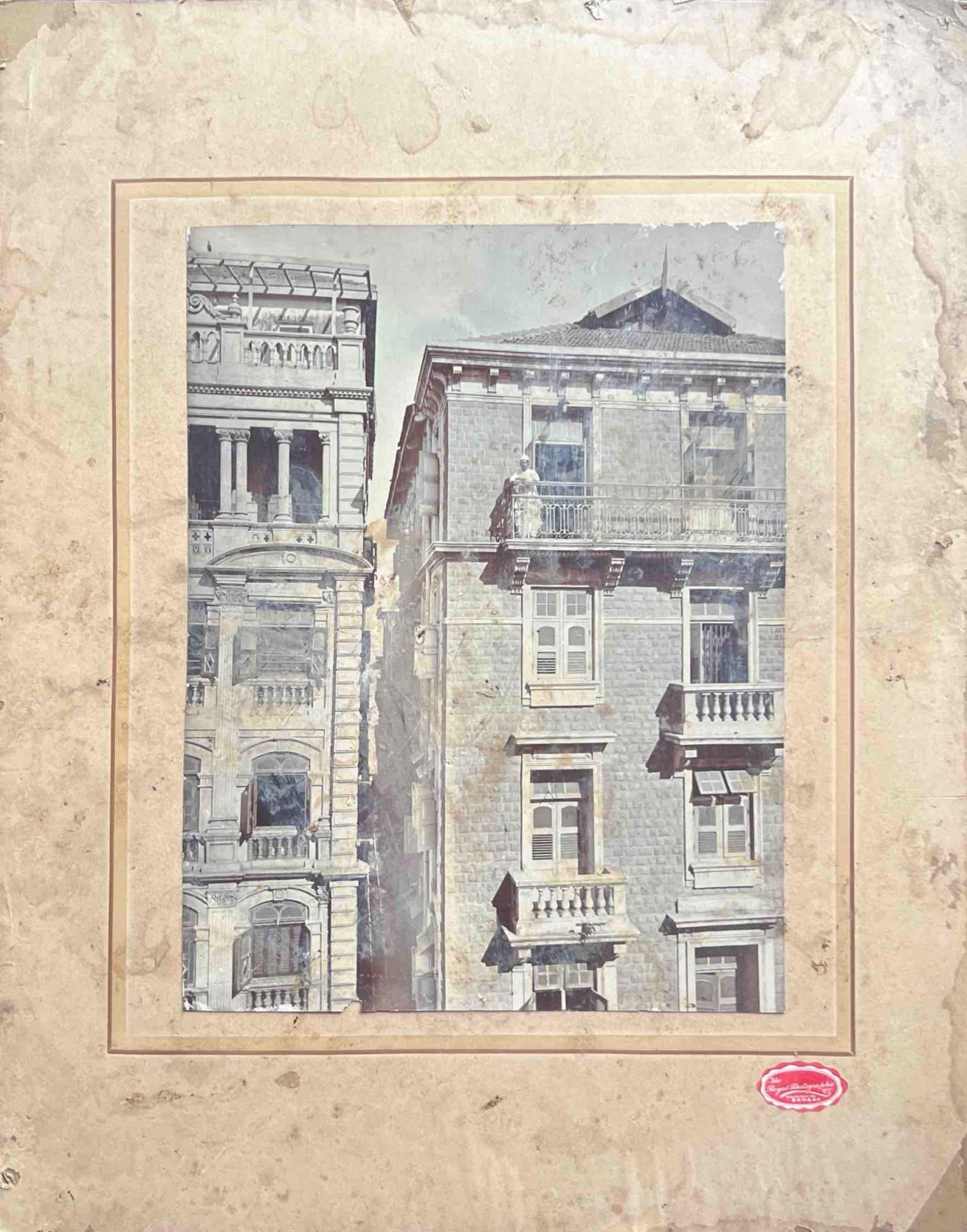 WEATHERED ARCHITECTURAL PHOTOGRAPH OF HISTORIC BUILDINGS: WEATHERED ARCHITECTURAL PHOTOGRAPH OF HISTORIC BUILDINGS A FADED AND AGED PHOTOGRAPH SHOWING TWO ADJACENT HISTORIC STONE BUILDINGS WITH CLASSICAL EUROPEAN-STYLE ARCHITECTURE. THE STRUCTURES FEATURE