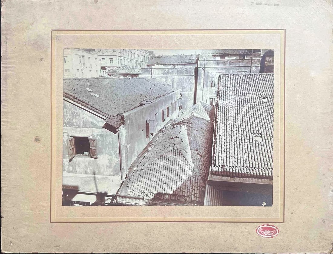 AGED ROOFTOPS OF HISTORIC URBAN BUILDINGS: AGED ROOFTOPS OF HISTORIC URBAN BUILDINGS A VINTAGE PHOTOGRAPH SHOWING WEATHERED TILED ROOFS AND AGED PLASTER WALLS OF MULTIPLE CONNECTED BUILDINGS IN A DENSE CITY AREA. SOME ROOF SECTIONS APPEAR DAMA