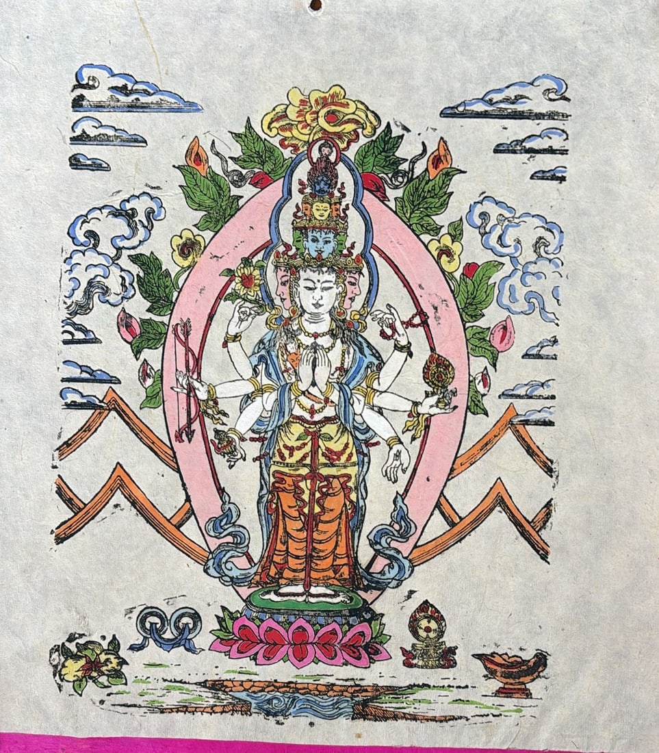 UNTITLED | HAND-COLORED WOODBLOCK PRINT ON HANDMADE HIMALAYAN PAPER | 20TH CENTURY: A TRADITIONAL TIBETAN HAND-COLORED WOODBLOCK PRINT DEPICTING THE ELEVEN-FACED, EIGHT-ARMED DEITY AVALOKITESHVARA (EKADASAMUKHA), THE BODHISATTVA OF COMPASSION. THE CENTRAL FIGURE STANDS UPON A LOTUS T