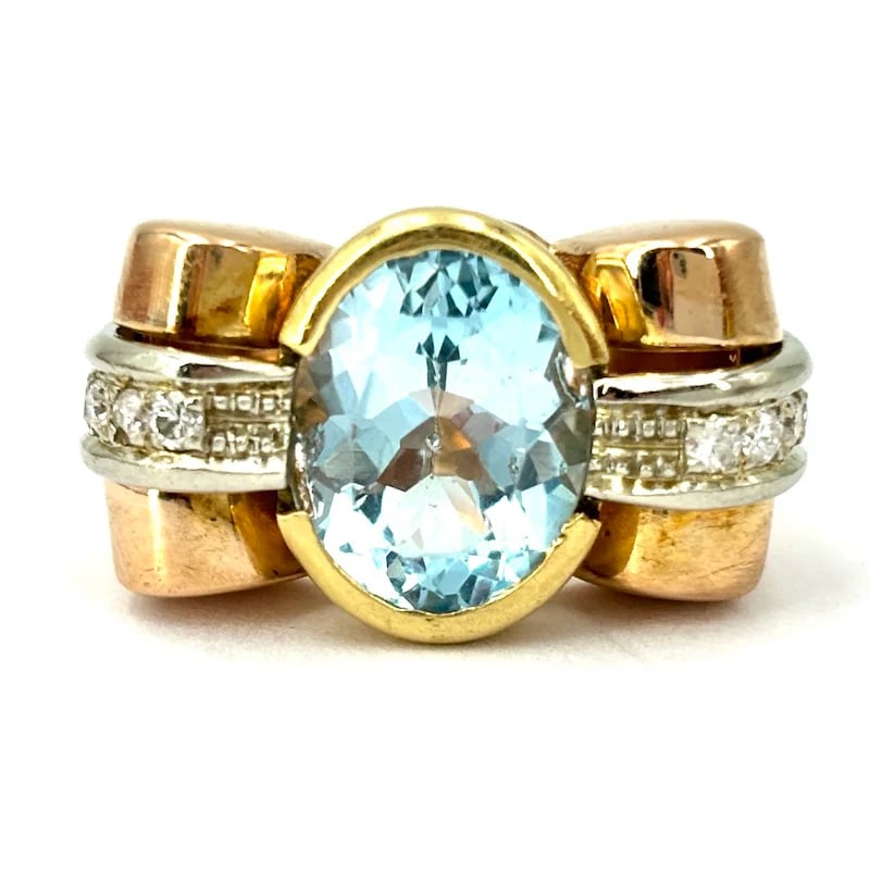 A Blue Oval Topaz is set on an 80’s Vintage 18k Solid Gold Ring weighing 11.97gr with of Diamonds: A Vibrant and Unforgettable Blue Oval Topaz is set on an 80’s Vintage 18k Solid Gold Ring weighing 11.97gr, accented by brilliant-cut diamonds on the sides. Ring weight: 11.97gr Ring size: 6.5 Front