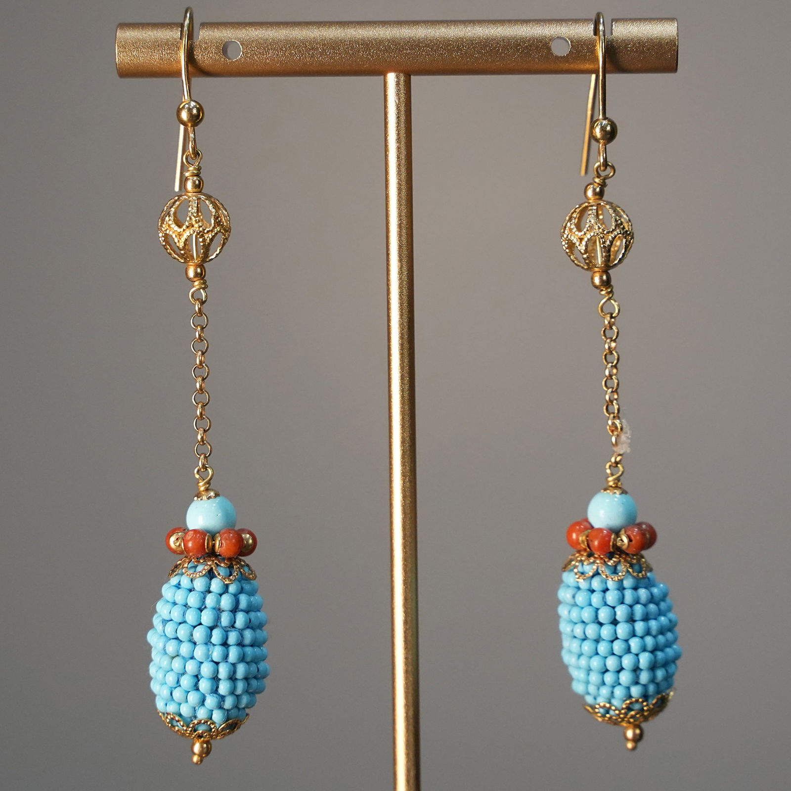 Cluster inspired Design 18K Yellow Gold Drop Earrings with Turquoise Beads and Coral,, 7.68 gr: Delicate and original drop earrings crafted in 18K yellow gold, featuring a playful cluster-inspired motif suspended on fine chains. Adorned with tiny turquoise beads and vibrant red coral accents, th