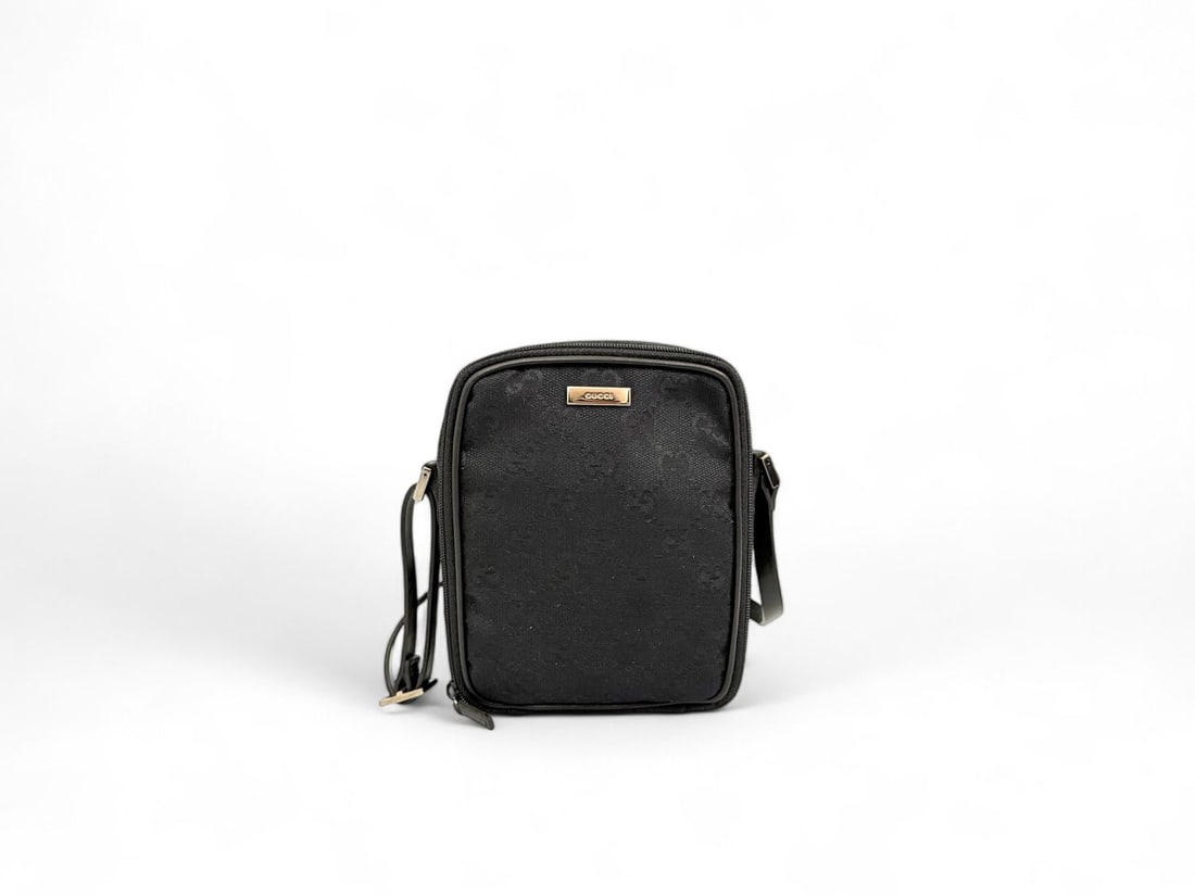 Gucci Black Canvas Men's Pouch Silver Hardware: Distinctive Gucci men's pouch crafted from robust black canvas, defining a sharp masculine aesthetic. Detailed with modern silver hardware, this compact bag is the perfect synthesis of practicality an