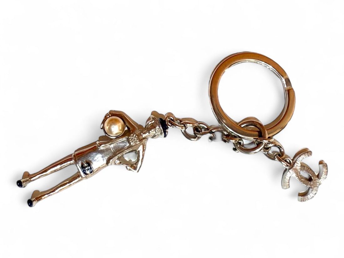 Chanel Silver Metal Charm Boxed - Dazzling & Collectible: Delightful Chanel charm crafted from polished silver-tone metal, reflecting the Maison's attention to detail. This gleaming accessory adds a signature touch of luxury to your favorite handbag or keys.