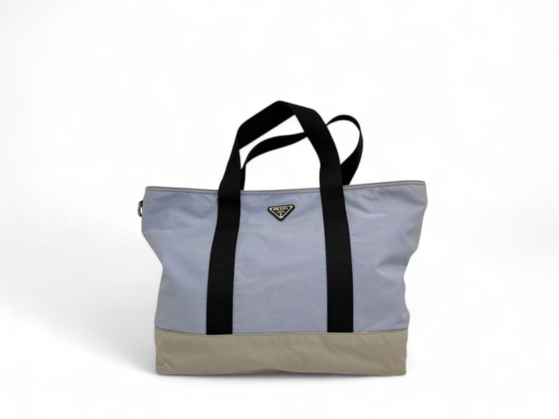 Prada Light Blue & Beige Shopper - Artistic & Luminous Canvas: A stunning Prada shopper featuring a unique and artistic color palette of light blue, beige, and black canvas. This luminous accessory, accented with polished silver hardware, offers a fresh and sophi