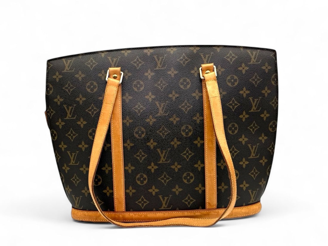 Louis Vuitton Babylone Monogram - Statuesque & Refined Elegance: The statuesque Louis Vuitton Babylone, a shoulder bag celebrated for its structured silhouette and refined presence. Crafted in the eternal Monogram canvas with natural cowhide straps and gold hardwar