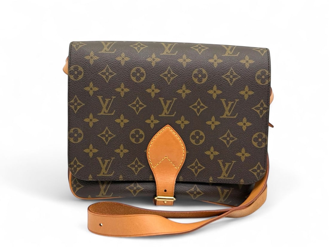 Louis Vuitton Iconic Cartoucherie Monogram: The iconic Louis Vuitton Cartoucherie, a model inspired by equestrian heritage and loved for its robust, structured charm. Crafted in signature Monogram canvas with natural cowhide buckle details and