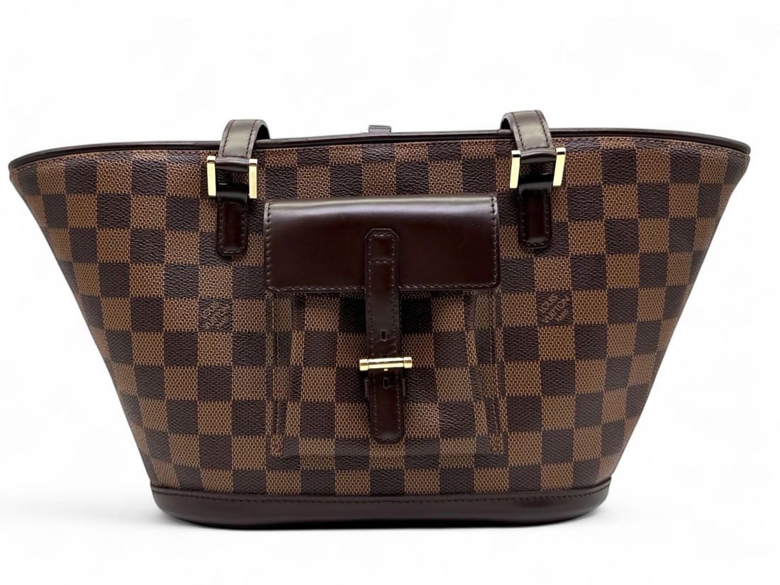 Louis Vuitton Manosque PM Damier Ebene - Sophisticated Masterpiece: The magnificent Louis Vuitton Manosque PM, a sculptural masterpiece in Damier Ebene canvas that redefines the concept of the luxury tote. Featuring unique exterior pockets and rich gold hardware, its
