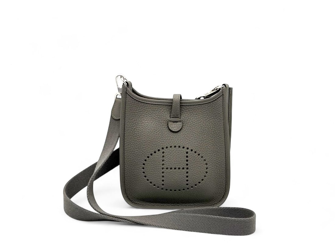 Hermes Evelyne TPM Gris Meyer Clemence - Exquisite & Rare Mini Treasure: The breathtaking Hermes Evelyne TPM, the most coveted mini-bag in the world, presented in the sophisticated and rare Gris Meyer shade. Crafted from premium Taurillon Clemence leather with Palladium ha