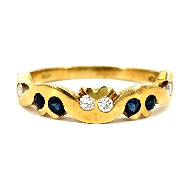 Charming Vintage Yellow Gold 18kt Band Ring with 0.24ct Sapphires and 0.14ct Diamonds - 3.74gr: Charming vintage yellow gold 18kt band ring adorned with sparkling sapphires and brilliant-cut diamonds. This feminine and romantic piece features a delicate scalloped design, perfect for retro-inspir