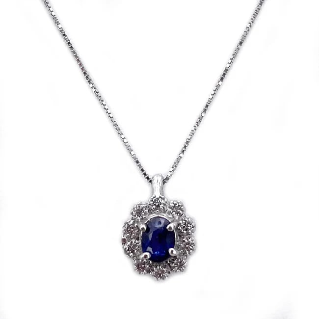 A 0.34ct Sapphire is on this Charming floral-inspired pendant necklace with 0.05ct Diamonds - 1.19gr: Charming floral-inspired pendant necklace crafted in 18K white gold, featuring an oval sapphire framed by shimmering diamonds in a delicate daisy motif. The pendant comes with a sleek Venetian box cha