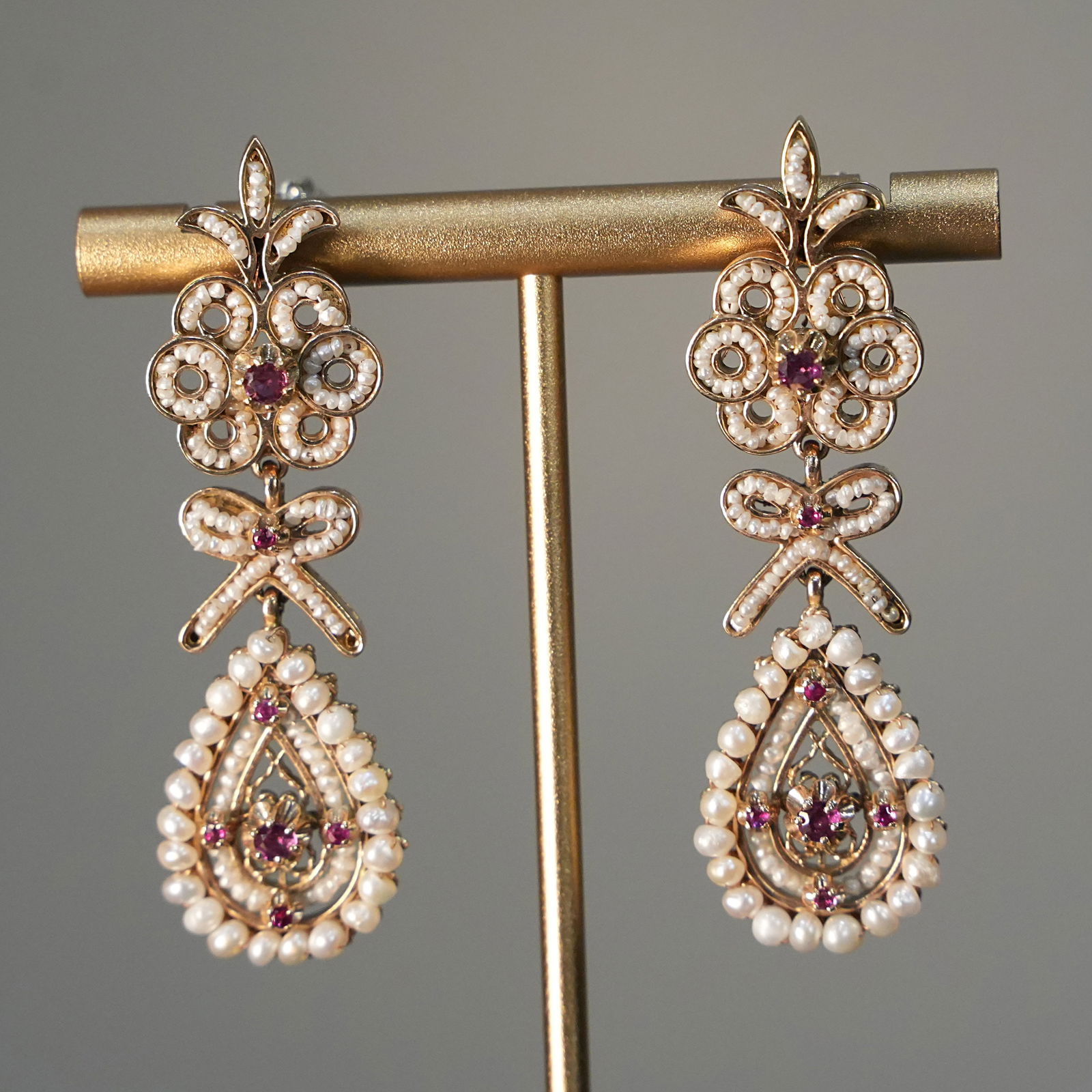 Victorian Style 12K Yellow Gold Drop Earrings with small Pearls and Rubies, 16.78 gr: Graceful drop earrings crafted in 12K yellow gold, designed with a stud post and butterfly backing, complemented by a pearl butterfly insert with post. Inspired by 19th-century aesthetics, these earri