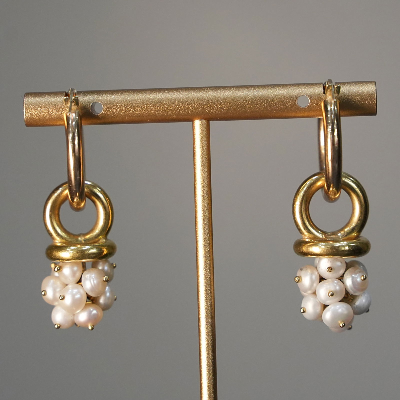 Artisanal Vintage 18K Yellow Gold Hoop Earrings with Cluster of Natural Pearls, 9.89 gr: Vintage yellow gold hoop earrings crafted in 18K, featuring a suspended cluster of tiny natural pearls. The golden hoops support the pearl clusters, creating a dynamic, flowing design with an organic