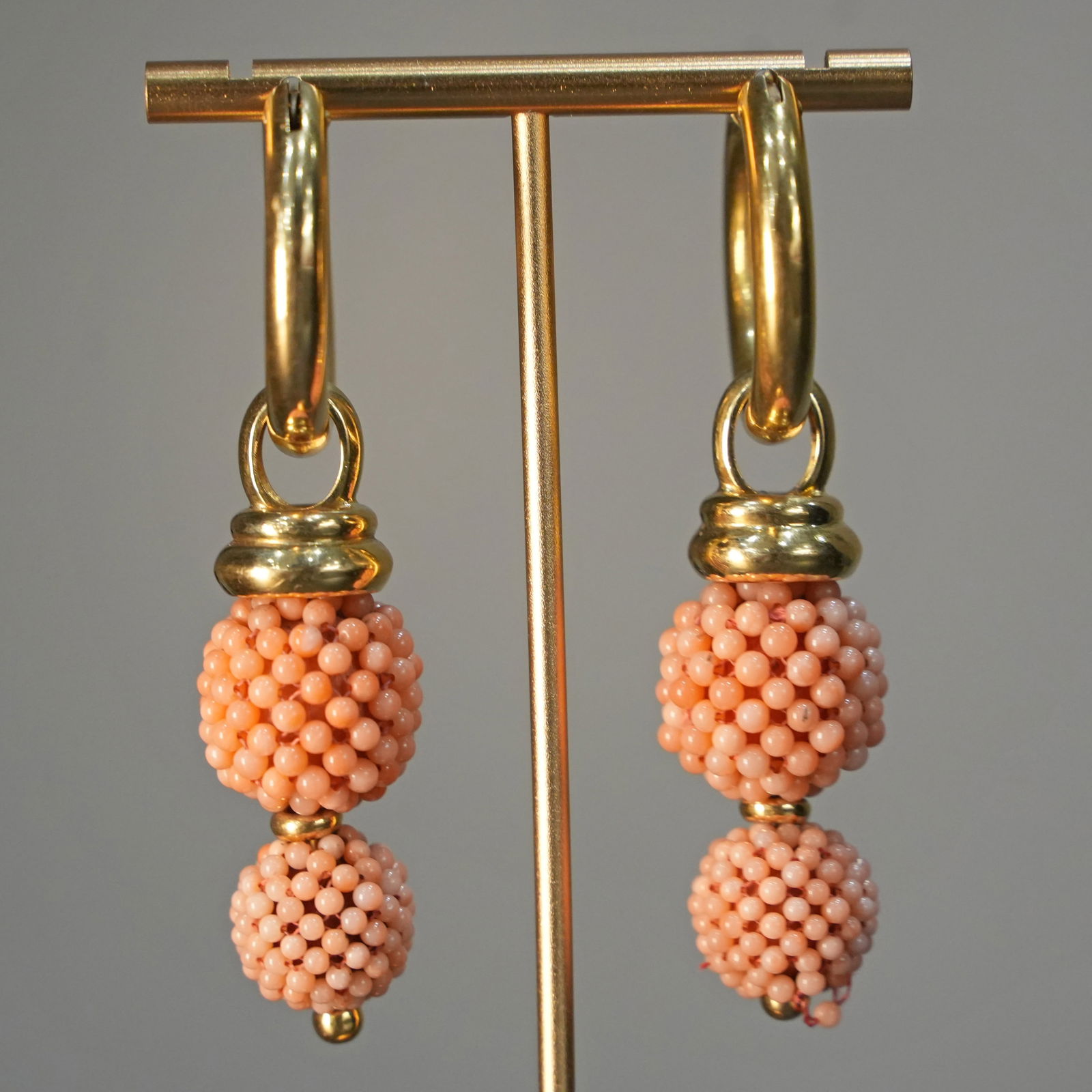 Striking 18K Yellow Gold Hoop Earrings with Double Pink Pearl Cluster Pendants 28.85gr: Striking hoop earrings made in 18K yellow gold, designed with suspended pendants featuring two clusters of pink pearls on each earring. The layered arrangement creates rich volume and gentle motion, b