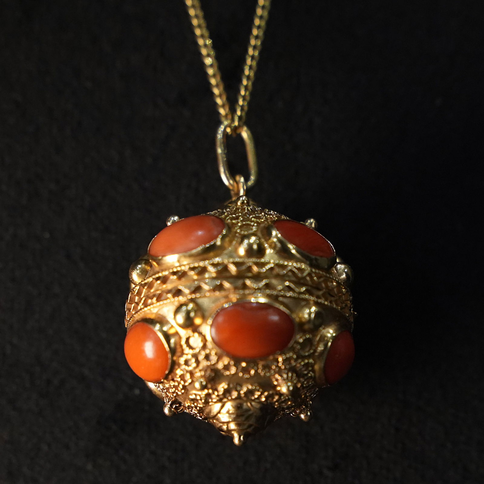 Exclusive and Artistic 18kt Yellow Gold Spherical Pillbox Pendant with Red Coral Cabochons, 16.37gr: Exclusive 18kt yellow gold spherical pillbox pendant featuring intricate filigree, micro-granulation, and embossed geometric patterns, enhanced by symmetrically set natural red coral cabochons for a w