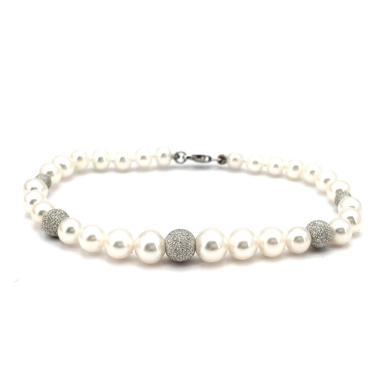 Akoya scaled bead and white gold boulle bracelet; 19 cm - 9.14 gr.: A wonderful timeless and highly refined classic! 19 cm long, single-strand bracelet of Japanese Akoya pearls, scaled from 5-7.5 mm in diameter. Diamond-effect worked boulle and 18 kt white gold lobste