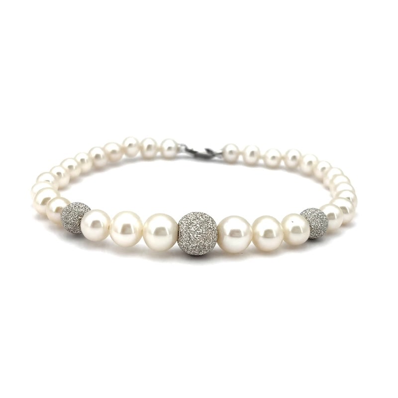 Akoya scaled bead and white gold boulle bracelet; 18 cm - 8.77 gr.: A wonderful timeless and highly refined classic! 18 cm long, single-strand bracelet of Japanese Akoya pearls, scaled from 5-7.5 mm in diameter. Diamond-effect worked boulle and 18 kt white gold lobste