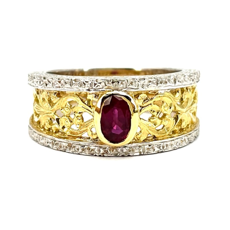 Florentine-style openwork band ring, ruby and two-tone gold; 8.7 gr.: Enchanting two-tone 18 kt gold openwork band ring with central oval ruby set among intricate fascinating openwork and minutely chiseled motifs. Textured white gold band edges. A ring inspired by the s