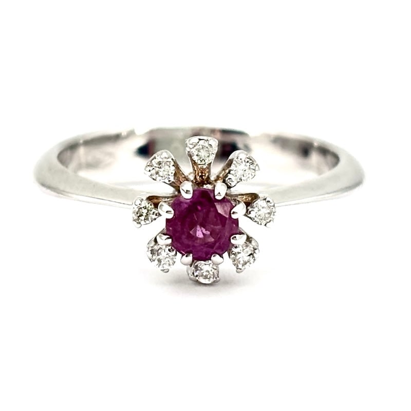 Circular ruby and diamond flower ring ; 3.68 gr.: Delightful white gold flower ring with central round-cut ruby framed by brilliants. A new, fresh, very accessible variant with a vaguely retro flavor! Our company's certification is available for